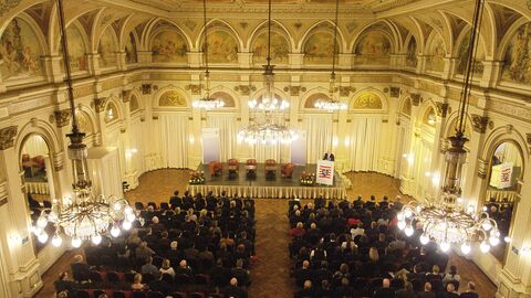 Blick in den Saal der Wiesbadener Casino-Gesellschaft beim 20. Herbstgespräch 2018. Auf dem Bild blickt man über das Publikum hinweg auf die Bühne.