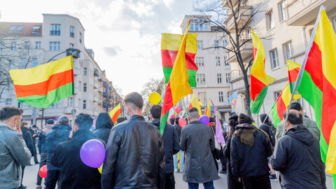 Symbolbild für Extremismus mit Auslandsbezug. Zu sehen sind kurdische Demonstrationsteilnehmer mit gelb-rot-grünen Fahnen, bei einer Demonstration anlässlich des Geburtstags von PKK-Gründer Abdullah Öcalan).