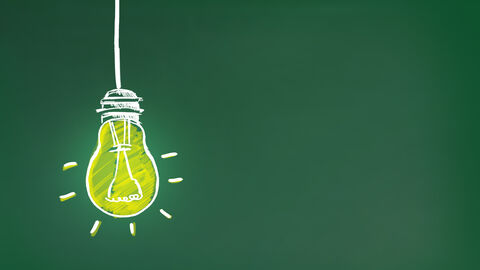 Abstrakte Darstellung einer leuchtenden Glühbirne vor grünem Hintergrund, Symbolbild 