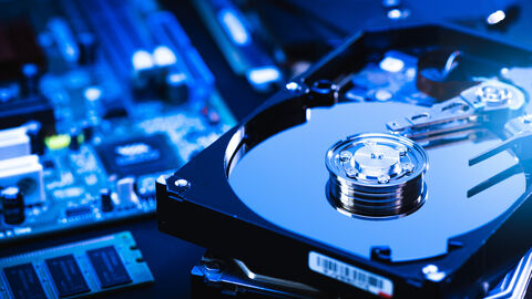 Ansicht einer Festplatte Auf dem Bild sieht man Bauteile eines Computers. Am rechten Rand des Bildes sieht man eine aufgeschraubte Festplatte