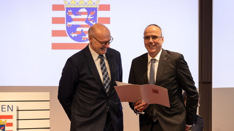 LfV-Präsident Bernd Neumann und Hessens Innenminister Peter Beuth vor einem Hessen-Wappen.