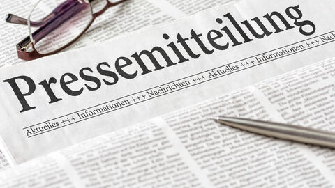 Zu sehen ist eine stilisierte Zeitung auf der das Wort "Pressemitteilung" zu lesen ist.